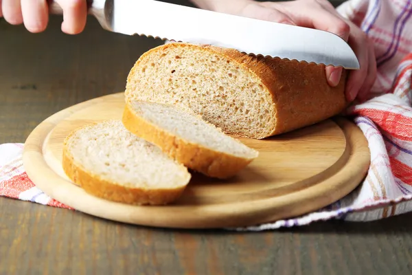 Manos femeninas cortando pan — Foto de Stock