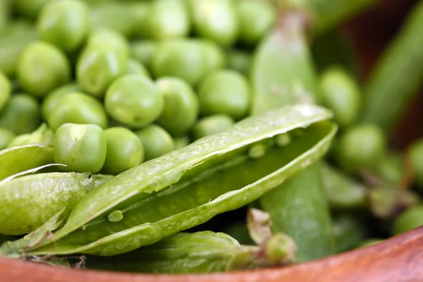 Groene erwten in houten schaal — Stockfoto