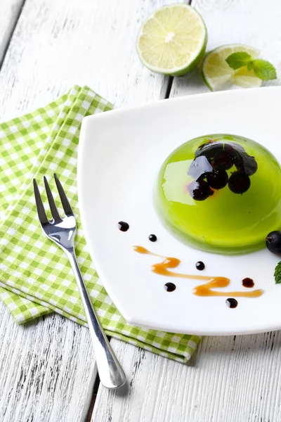 Green jelly with blackcurrant berries — Stock Photo, Image