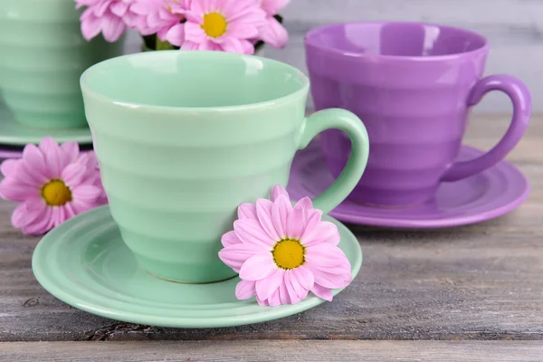 Kopjes en schotels met bloemen — Stockfoto