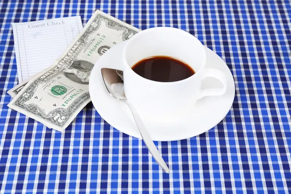 Чек, чашка кофе и деньги — стоковое фото