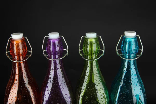 Färgglada flaskor på svart bakgrund — Stockfoto