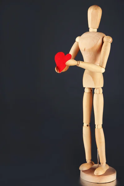 Wooden mannequin holding red heart — Stock Photo, Image