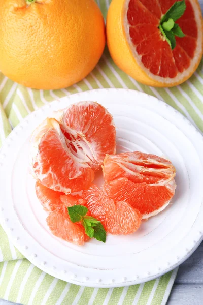 Ripe peeled grapefruits on plate — Stock Photo, Image