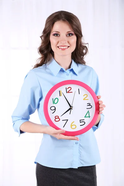 Junge Geschäftsfrau mit Uhr im Zimmer — Stockfoto