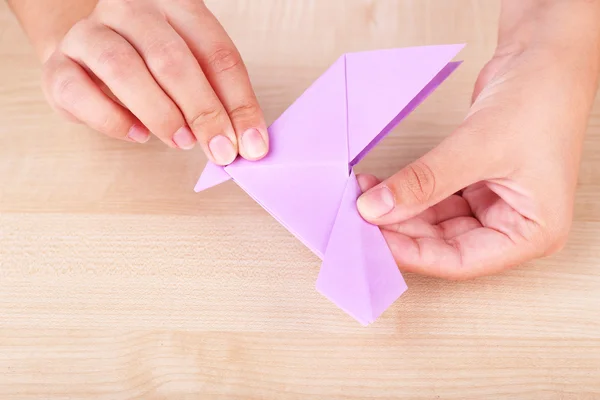 Manos femeninas sosteniendo pájaro origami — Foto de Stock