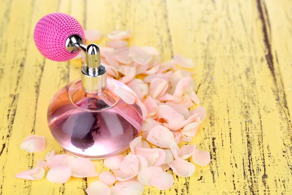 Perfume bottle with petals — Stock Photo, Image