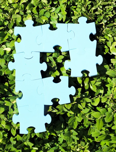 Puzzle kousky na zelené trávě — Stock fotografie