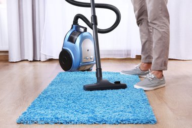 Man doing vacuum cleaning in room clipart