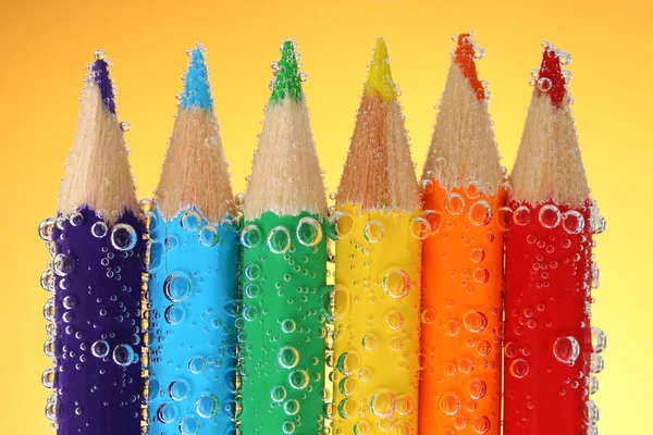 Kleurrijke potloden in water — Stockfoto