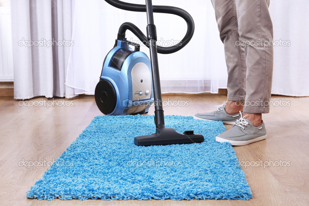 Man doing vacuum cleaning in room