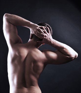 yakışıklı genç kaslı sporcu, koyu arka plan üzerinde