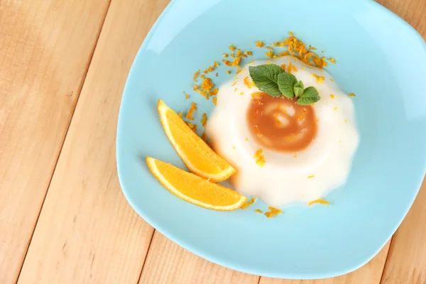 Panna Cotta con scorza d'arancia e salsa caramello, su fondo di legno — Foto Stock