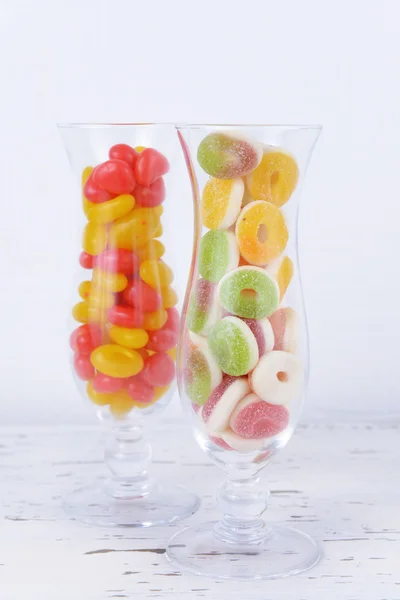 Doces de frutas coloridas diferentes em óculos na mesa no fundo claro — Fotografia de Stock
