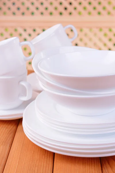 Set of white dishes on table on light background — Stock Photo, Image
