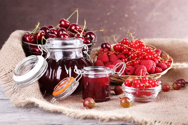 Bobule jam v sklenice na stole, detail — Stock fotografie