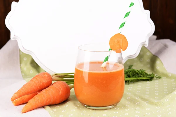 Copo de suco de cenoura e cenouras frescas na mesa de perto — Fotografia de Stock