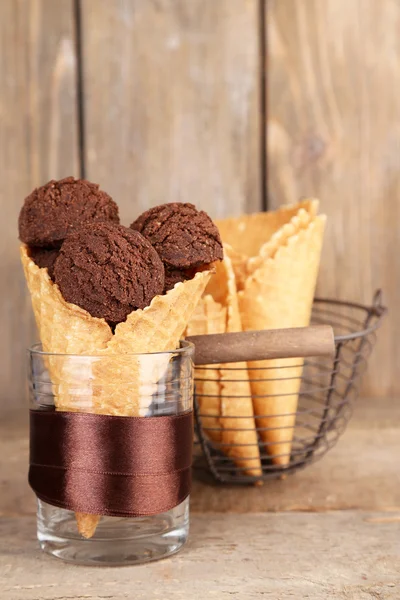 Înghețată de ciocolată gustoasă în con de vafe pe fundal maro din lemn — Fotografie, imagine de stoc