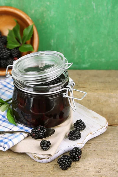 Smakelijke blackberry jam en verse bessen, op houten tafel — Stockfoto