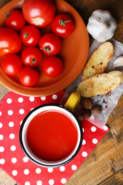Domácí rajčatové šťávy v barevný hrnek, toasty a čerstvá rajčata na dřevěné pozadí — Stock fotografie