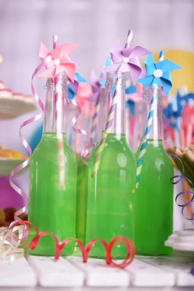 Botellas de bebida con paja sobre fondo decorativo — Foto de Stock