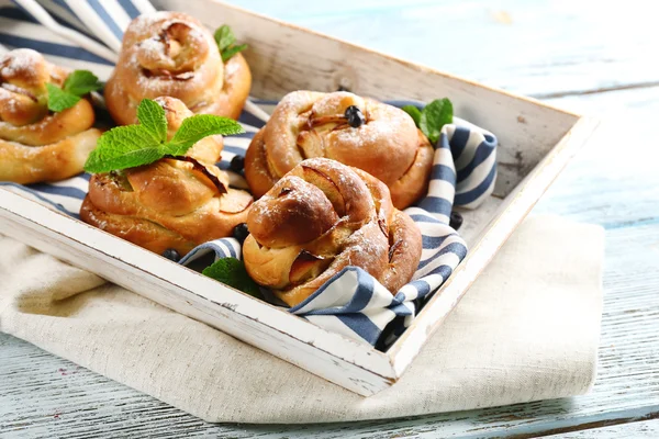 Tasty buns with berries on tray on table close-up — Stock Photo, Image