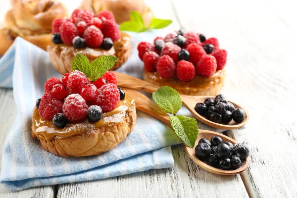 Süße Kuchen mit Beeren auf dem Tisch in Großaufnahme — Stockfoto