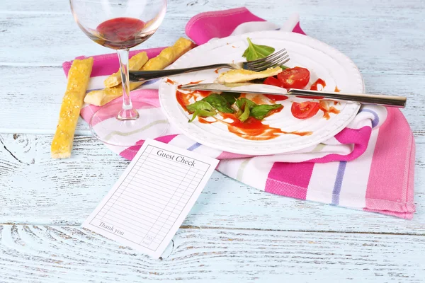 Check and remnants of food on table in restaurant — Stock Photo, Image