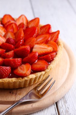 Ahşap arka planda çilekli tart