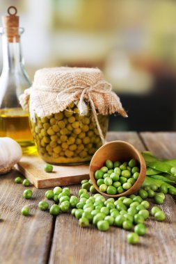 kase ve cam kavanoza peçeteye parlak zemin üzerine ahşap masa üzerinde taze ve konserve bezelye