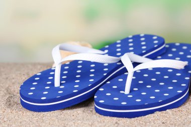 kum, doğa arka plan üzerinde renkli parmak arası terlik