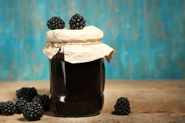 Tasty blackberry jam and fresh berries, on wooden background clipart