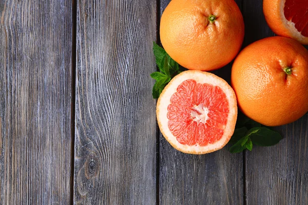 Спелые грейпфруты на деревянном фоне — стоковое фото