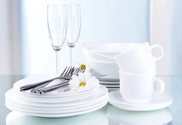 Set de platos blancos sobre mesa sobre fondo claro —  Fotos de Stock