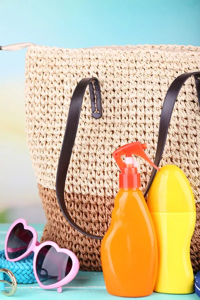 Summer wicker bag with accessories on nature background — Stock Photo, Image