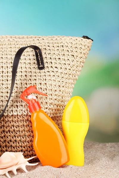 Bolsa de mimbre de verano con accesorios sobre arena, sobre fondo natural —  Fotos de Stock