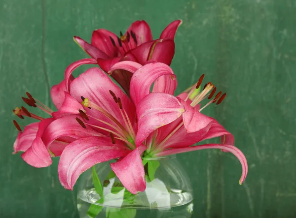 Beautiful lily in vase on wooden background — Stock Photo, Image