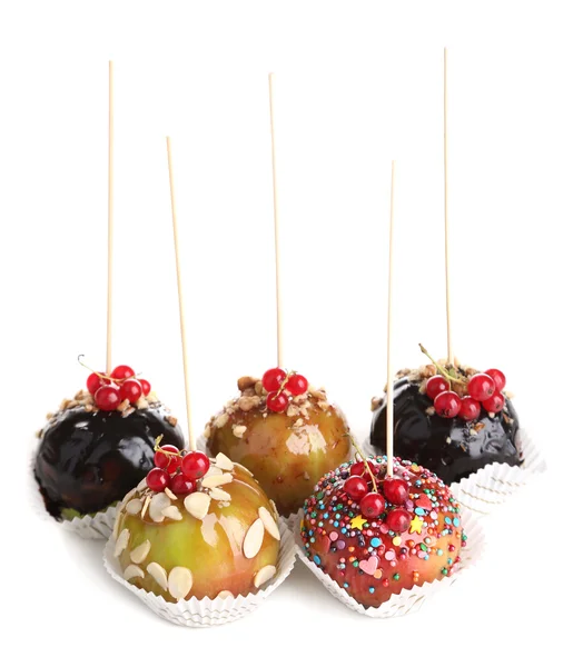 Mele dolci al caramello su bastoncini con bacche, su tavolo di legno — Foto Stock