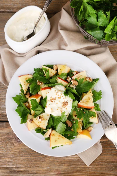 Green salad with apples, walnuts and cheese on wooden background — Stock Photo, Image