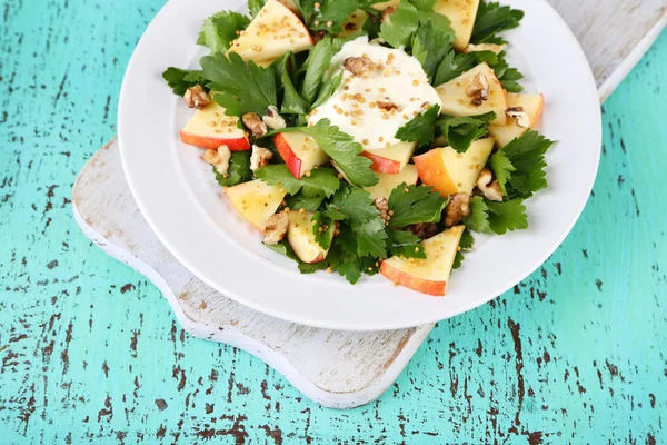 Salada verde com maçãs, nozes e queijo na cor de fundo de madeira — Fotografia de Stock