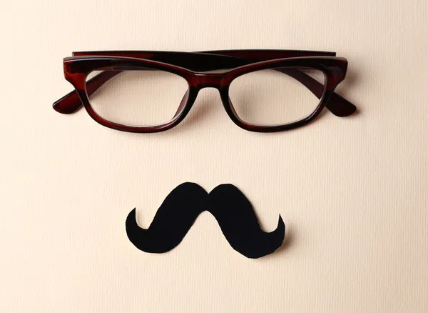 Lunettes et moustache formant le visage de l'homme sur fond beige — Photo