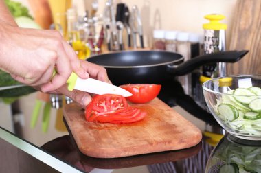 Adam mutfakta yemek pişiriyor.