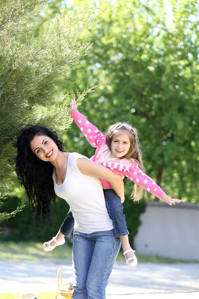 Happy mom and daughter. Walk in the green park — Stock Photo, Image