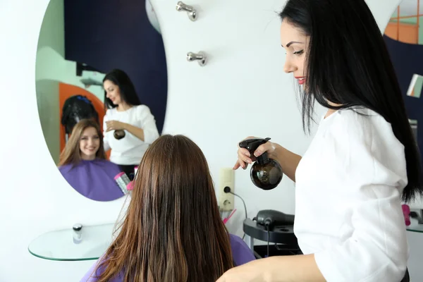 Mujer joven peluquera hacer peinado chica en salón de belleza —  Fotos de Stock