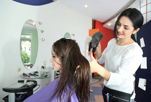 Mujer joven peluquera hacer peinado chica en salón de belleza —  Fotos de Stock