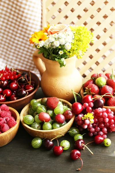 Välsmakande bär och färska blommor — Stockfoto