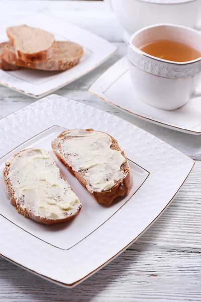 Pão fresco e manteiga caseira no prato em fundo de madeira — Fotografia de Stock