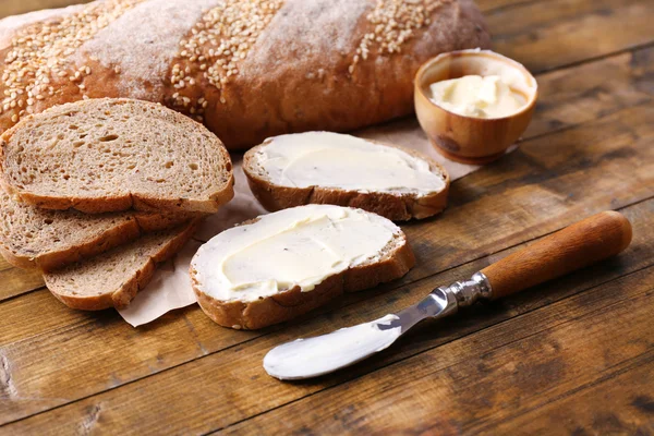焼きたてのパン、自家製のバターを木製の背景 — ストック写真