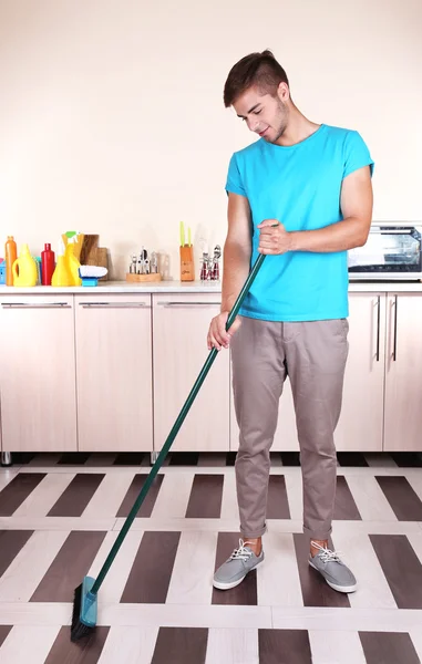 Joven hombre limpieza piso —  Fotos de Stock
