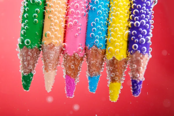 Färgglada pennor i vatten — Stockfoto